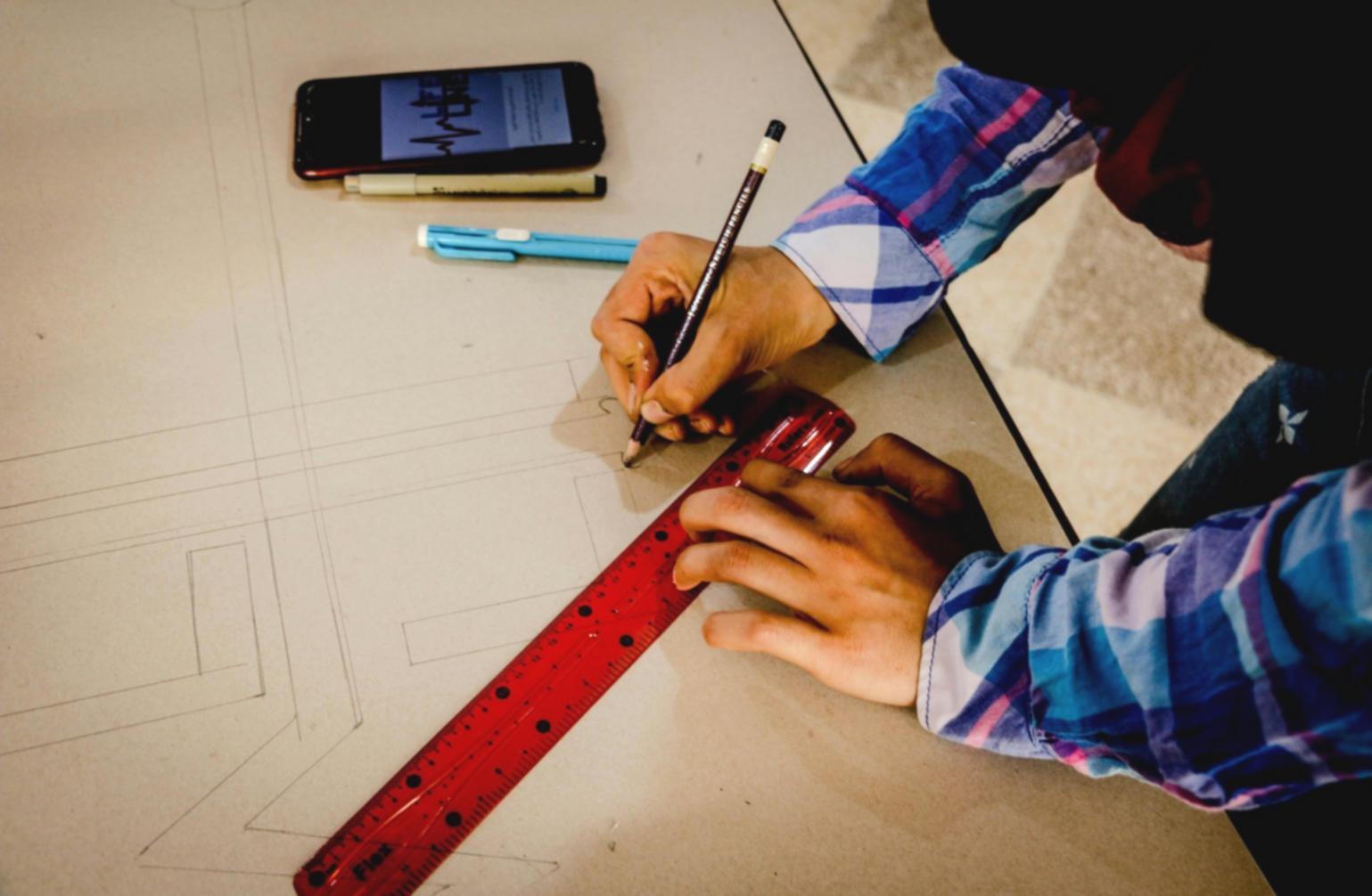 Zeichenmaterialien und erste Skizzen auf einem Arbeitstisch